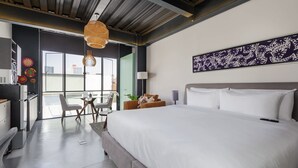 A modern hotel room with a large bed, a dining area with a table and chairs, a kitchenette, and a view of the city through large windows. - w* | Glorious Loft w/ Beautiful Deco in Roma Norte (Ciudad de México)