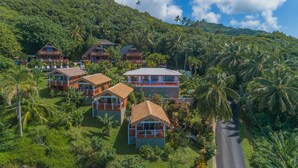 Un resort con varias cabañas rodeadas de exuberante follaje y palmeras.