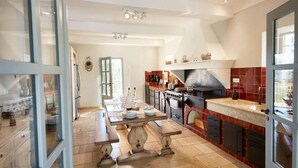 A spacious kitchen with a large island, a built-in oven, and a tiled backsplash. - Authentique Bastide Provençale au Cœur des Vignes D'un Domaine (Carcès)