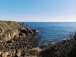 Paisaje costero con terreno rocoso y una vista despejada del mar.