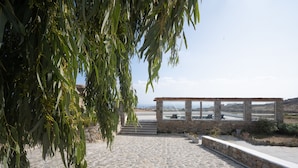 A stone-paved pathway leading to a stone structure with a view of the landscape. - Island Dreaming Opal 2 Bd w shared pool (Mykonos)