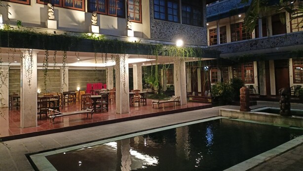 Un patio con piscina, mobiliario exterior y un edificio de arquitectura tradicional.