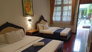 Habitación de hotel con dos camas, una mesita de noche con lámpara y un ventanal con cortinas.