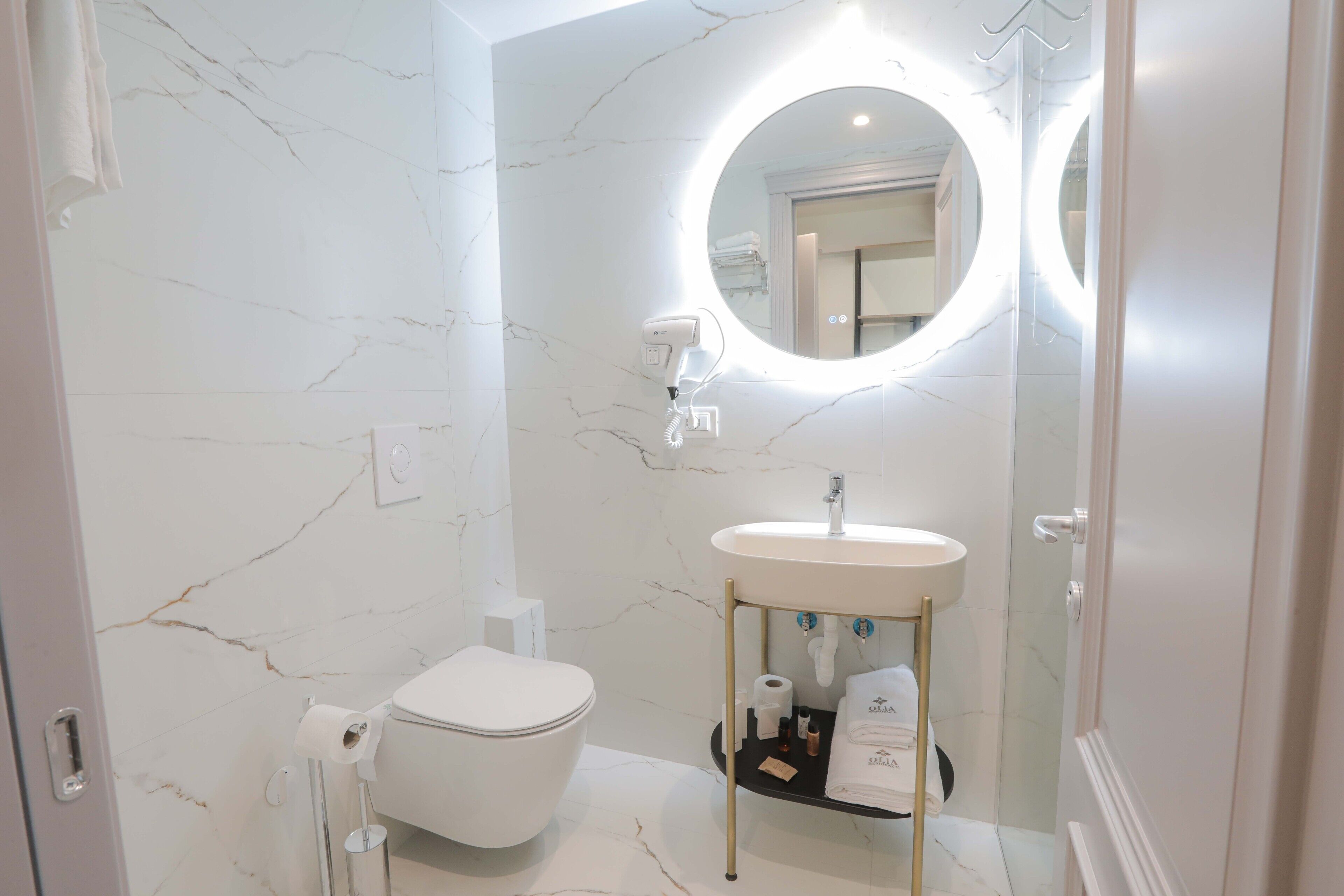 Un bagno moderno con il water, un lavandino e un mobile contenitore.