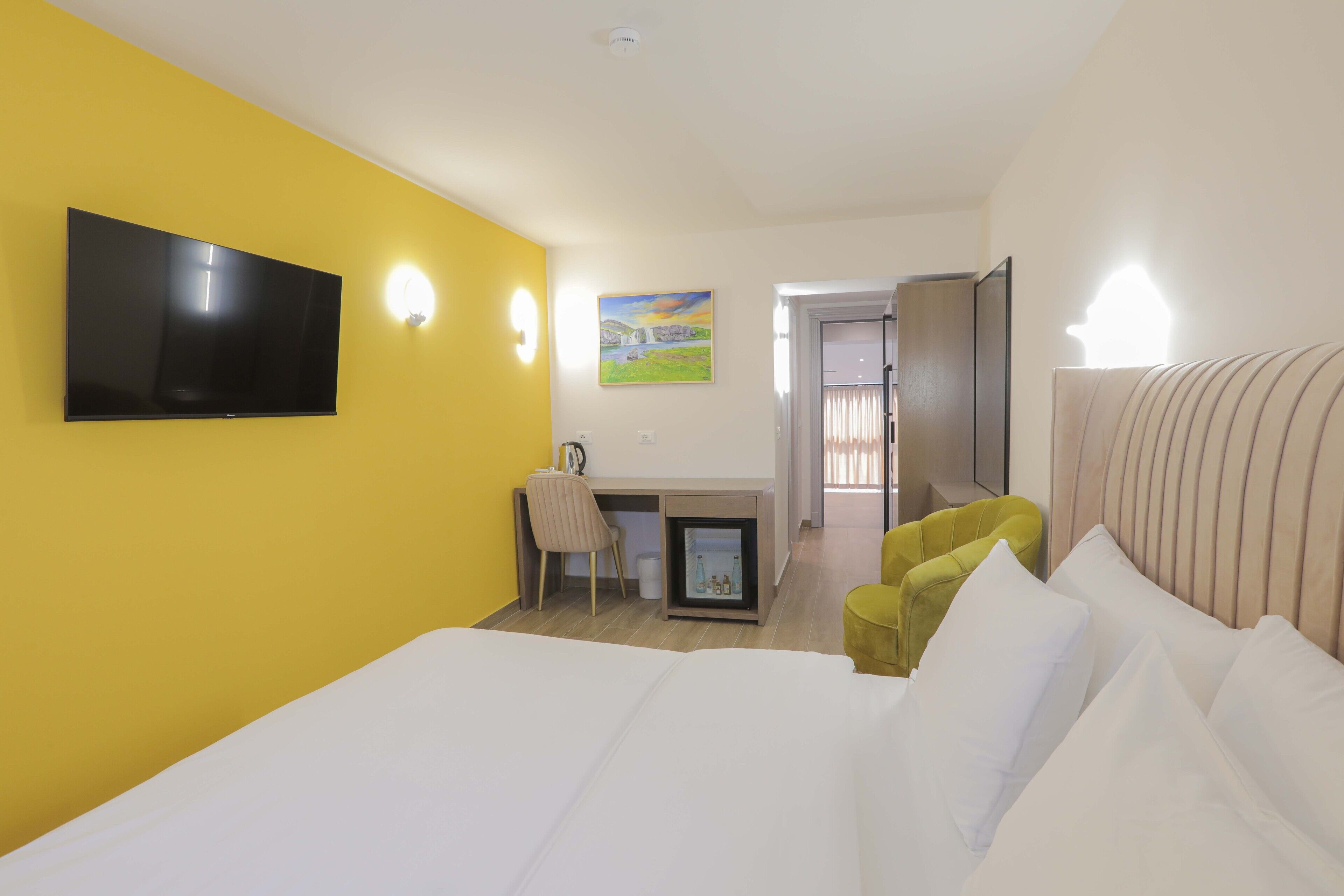 Een hotelkamer met een bed, bureau, stoel en televisie.