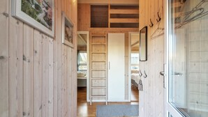 Ein Holzinnenraum mit einem Flur, der zu einem Schlafzimmer führt.