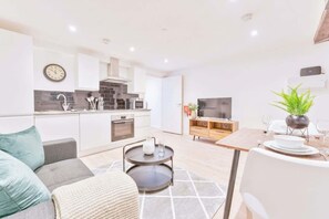 A modern apartment with a kitchen, dining area, and living room.