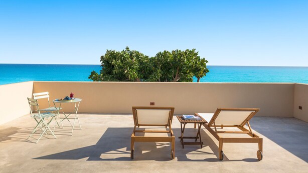 A terrace with a view of the sea, wooden furniture, and a small table with a drink. - Villa with pool, on the sea in Marina di Modica (Marina di Modica)