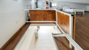 A room with a wooden floor, white walls, a bed with a white headboard, a small table, and a chair. - Awesome apartment in Grottaglie (Grottaglie)