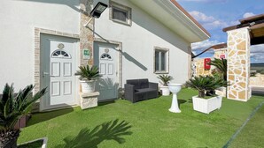 A building with two doors, a stone pillar, and a small outdoor seating area. - Awesome apartment in Grottaglie (Grottaglie)