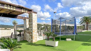 A well-maintained outdoor area with a trampoline, stone pillars, and a pergola. - Awesome apartment in Grottaglie (Grottaglie)
