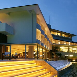 Et moderne hotel med en rummelig lobby, flere etager og en godt oplyst trappe.
