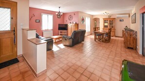 A spacious living area with a kitchen, dining table, and a green car parked outside. - Beautiful home in Mazan with WiFi (Mazan)
