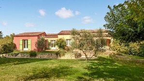 A two-story house with a stone wall and a well-maintained lawn. - Beautiful home in Mazan with WiFi (Mazan)