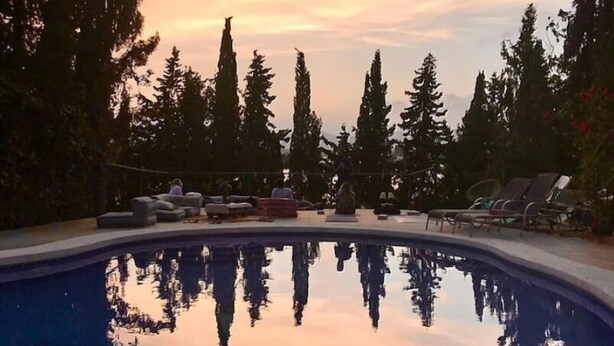 A swimming pool with reflections of trees and a sunset sky. - Bakit House - Casa Rural con Piscina Privada (Águilas)