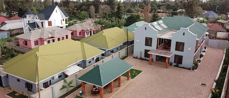Pátio com área de estar central, rodeado por edifícios com telhados verdes e uma variedade de estilos arquitetônicos.