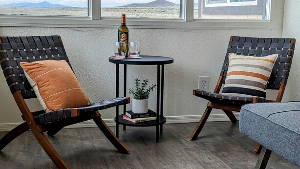 Two lounge chairs with cushions, a small table with a bottle and glasses, and a potted plant. - Quiet and Unique 2BR on Winery Row - The Elgin Project (Elgin)