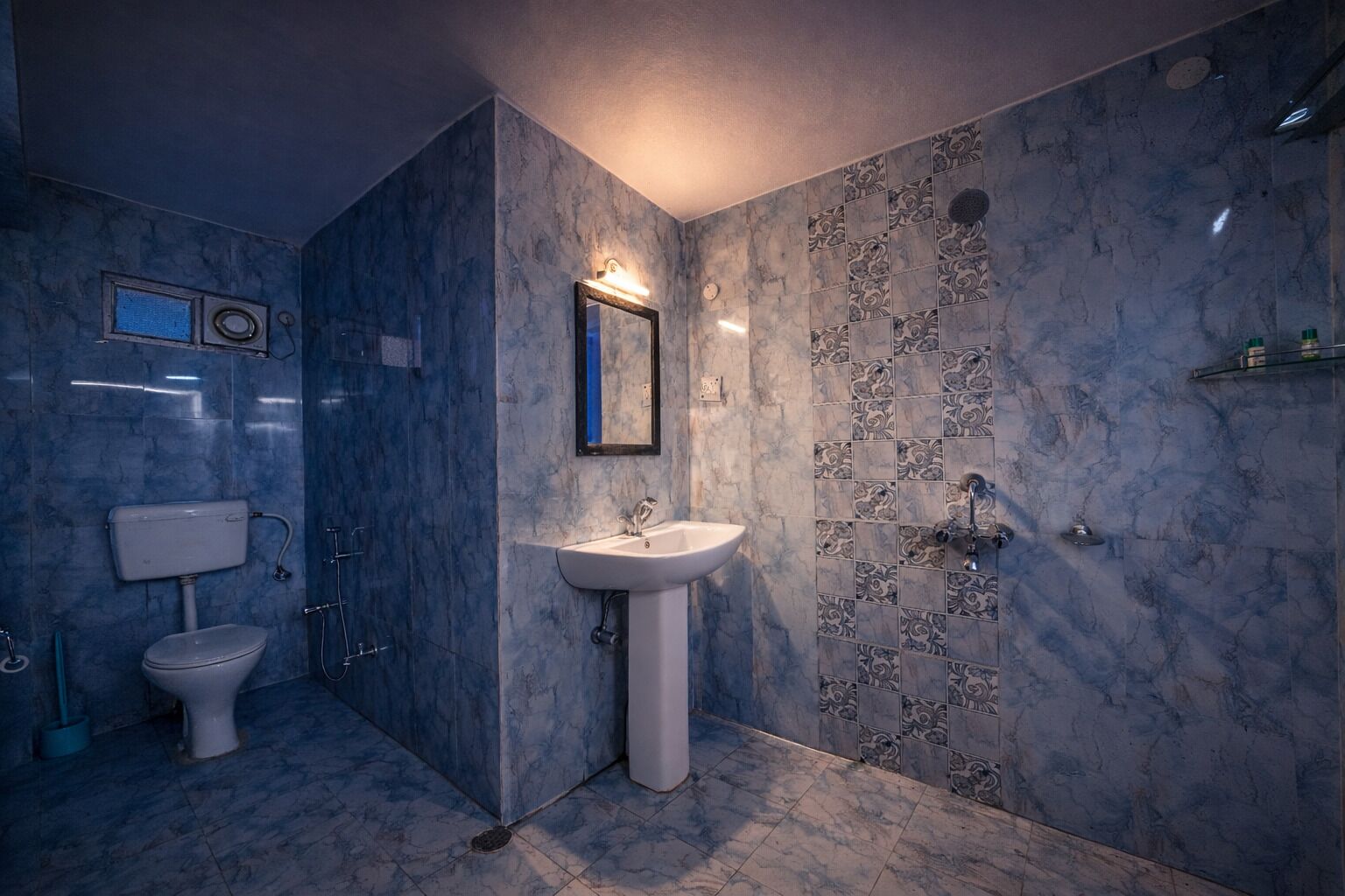 A bathroom with a toilet, sink, and shower.