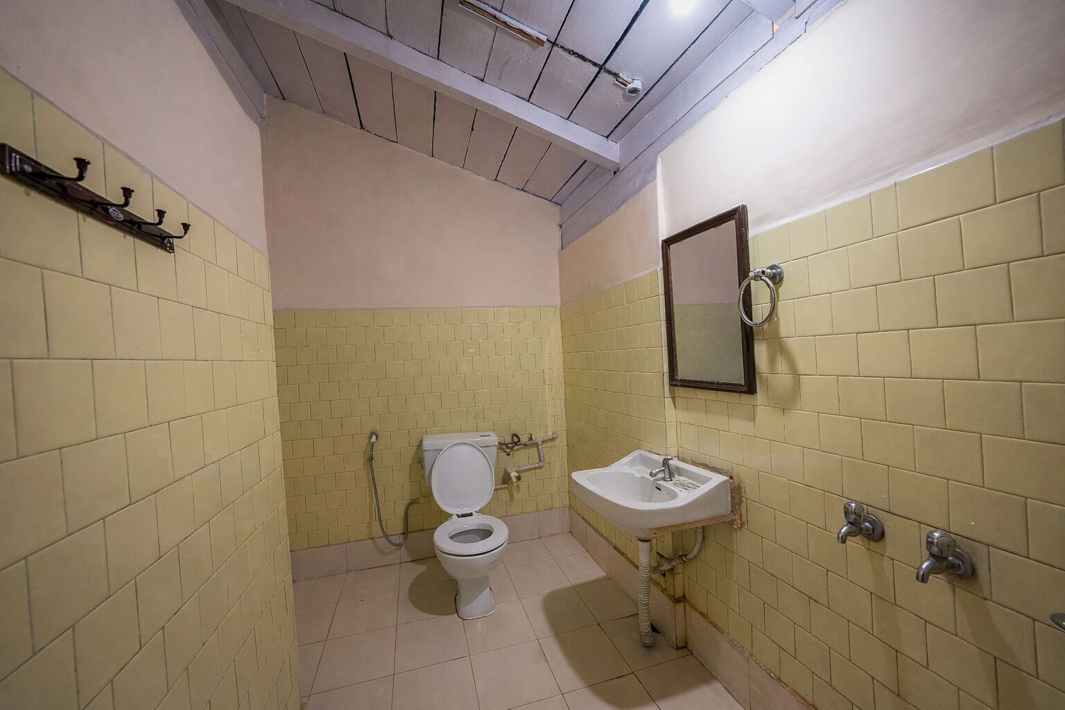 A small bathroom with a toilet, sink, and mirror.