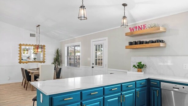 A modern kitchen with blue cabinets, a white countertop, and a stainless steel dishwasher. - Fritztown's Finest - Hot Tub, Fire Pit & Sleeps 10 (Fredericksburg)