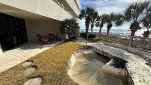Un cortile con piscina, palme e vista sull'oceano.