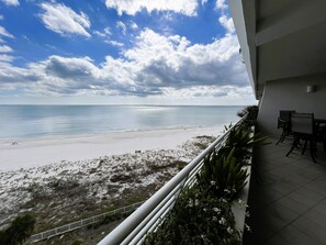 Un balcón con vista a la playa y al océano.