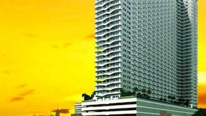 Un edificio de gran altura con un diseño arquitectónico moderno, que destaca por una estructura vertical y una serie de balcones.