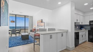A modern hotel room with a kitchen, dining area, and a balcony with a view. - Newly Renovated Coastal Living on the 17th Floor (Myrtle Beach)