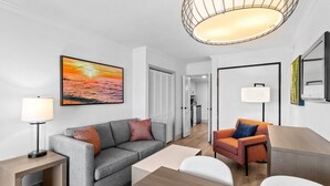 Un salon moderne avec un canapé gris, un fauteuil orange et une table basse en bois.