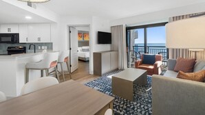Ein modernes Hotelzimmer mit Küche, Essbereich und einem Balkon mit Blick.