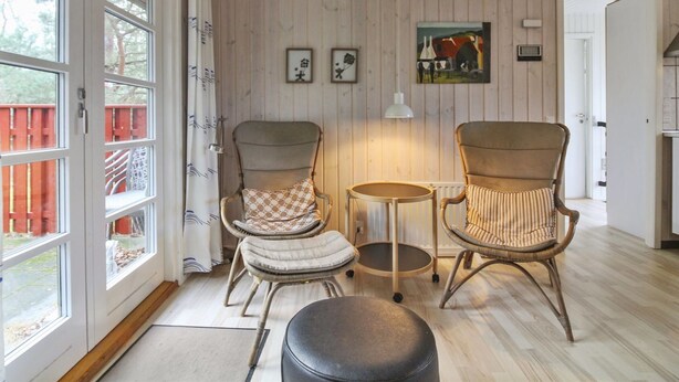 A cozy room with two wicker chairs, a small round table, and a black ottoman. - "Cvetanka" - 200m from the sea by Interhome (Nexø)