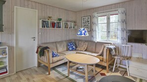 A cozy living room with a sofa, a coffee table, a bookshelf, and a television. - "Cvetanka" - 200m from the sea by Interhome (Nexø)