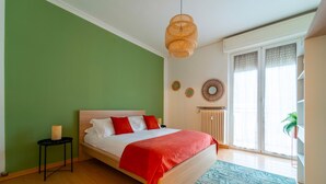 A bedroom with a bed, a small side table, a radiator, and a window with blinds. - Appartamento Gelso by Wonderful Italy (Como)
