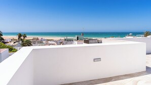 Eine Dachterrasse mit Blick auf Strand und Meer.