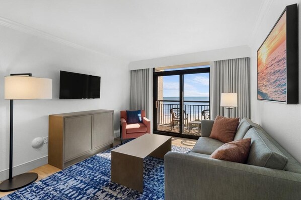 Enjoy a sea view from the large window, relax in the seating area with a sofa and armchairs, and unwind with a flat-screen TV.