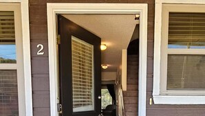 A wooden house with a black door and a number '2' on the wall. - Great location for exploring Northwest Arkansas! (Holiday Island)