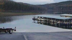 A large building with a flat roof, situated by a body of water. - Great location for exploring Northwest Arkansas! (Holiday Island)