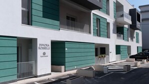 Un bâtiment moderne à la façade sobre, aux volets verts et sur lequel on peut lire l’inscription « DIMORA ROSSELLI ».