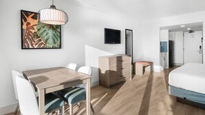 Een moderne hotelkamer met een houten bureau, een bed, een dressoir en een televisie.