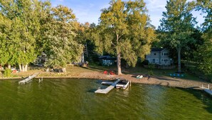 A lakeside property with a dock, boats, and a cabin. - Honeoye Cottage | 50' Lakefront | Dock | FLX (Honeoye)