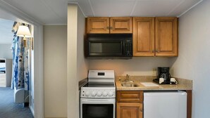A compact kitchen with a microwave, stove, and refrigerator. - Experience Serenity Oceanfront Suite 4th Floor (Myrtle Beach)