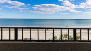 A beach view from a balcony with a railing, sandy beach, and ocean. - Experience Serenity Oceanfront Suite 4th Floor (Myrtle Beach)