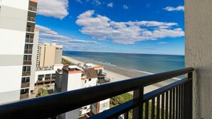 Un immeuble de grande hauteur doté d’un balcon donnant sur une plage.