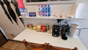 A kitchen counter with a coffee maker, toaster, and water bottles. - Bernina Station Suite: 30 Steps to the Red Train (Tirano)