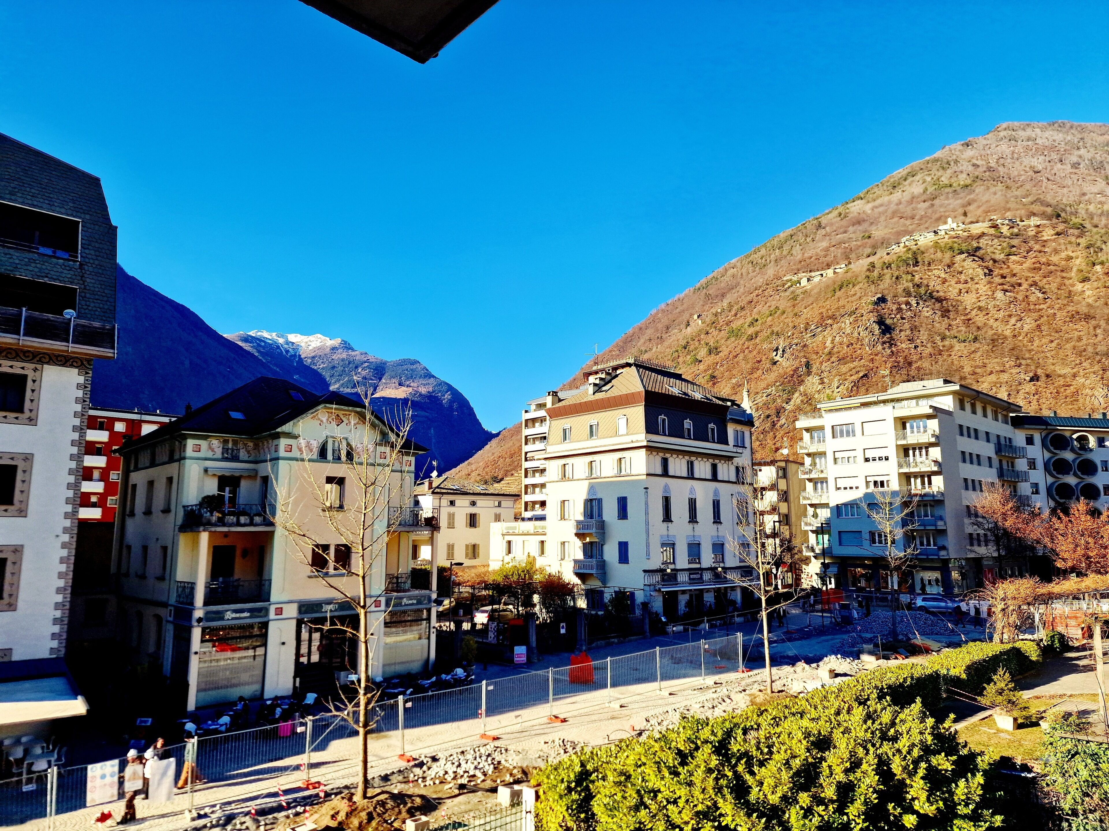 Une ville avec des bâtiments, une montagne et un ciel dégagé.
