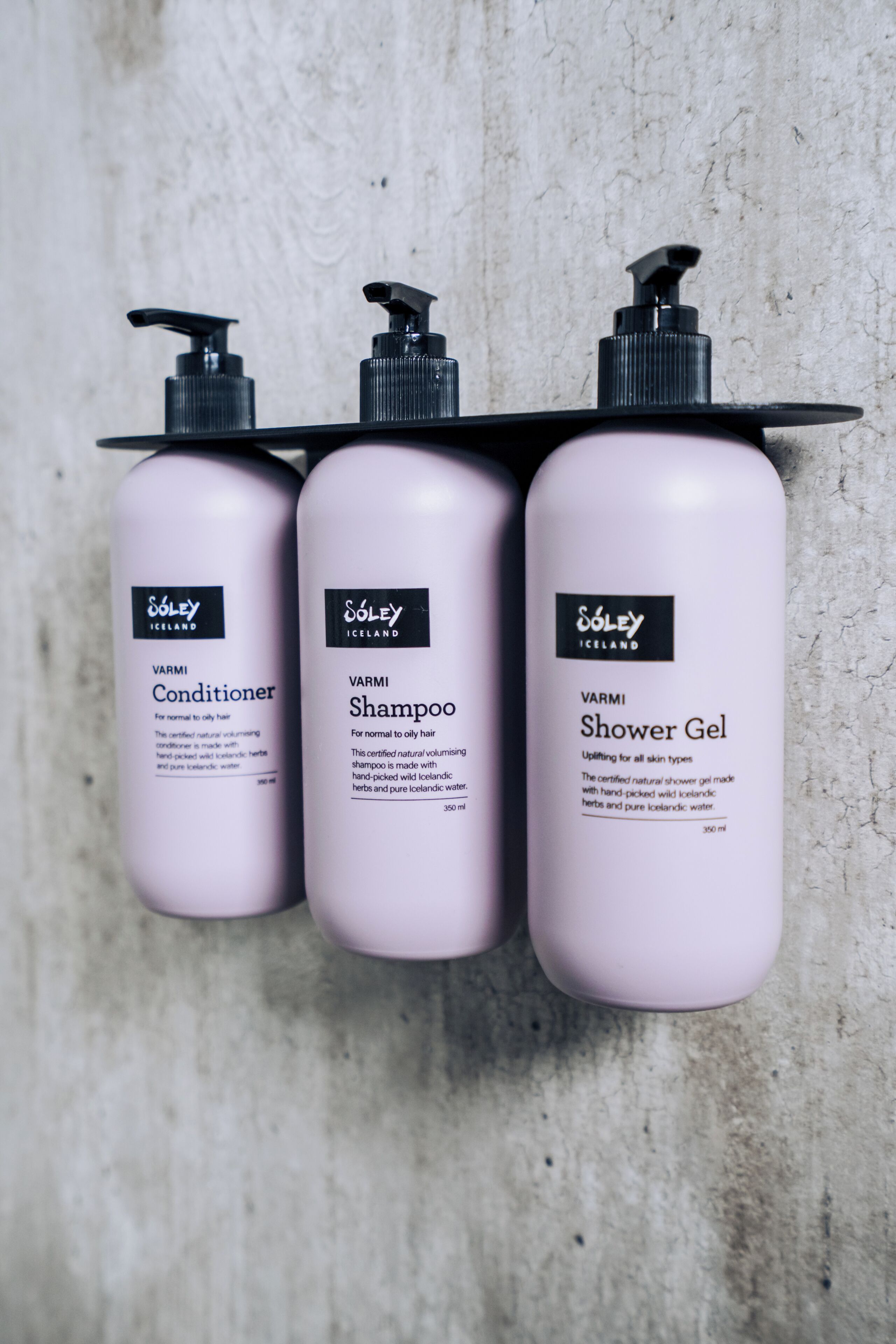 Three bottles of Soley Iceland products: conditioner, shampoo, and shower gel, each with a pump dispenser.
