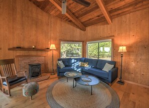 A cozy room with a blue sofa, a fireplace, and a large window.