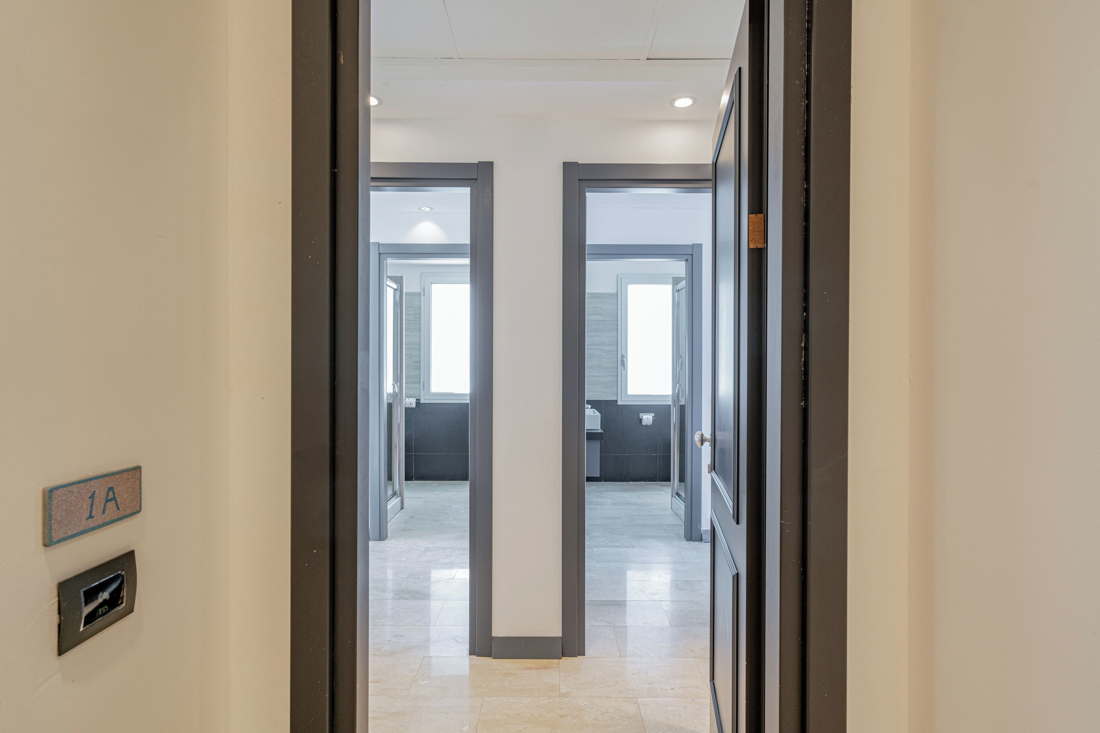 A hallway with a door labeled '1A' leading to a room with a window.