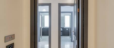 A hallway with a door labeled '1A' leading to a room with a window.