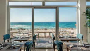 Un restaurante con terraza al aire libre y vistas al océano.